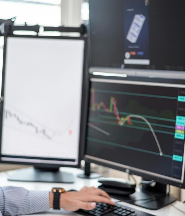 Financial analyst reviewing stock market charts and trading data